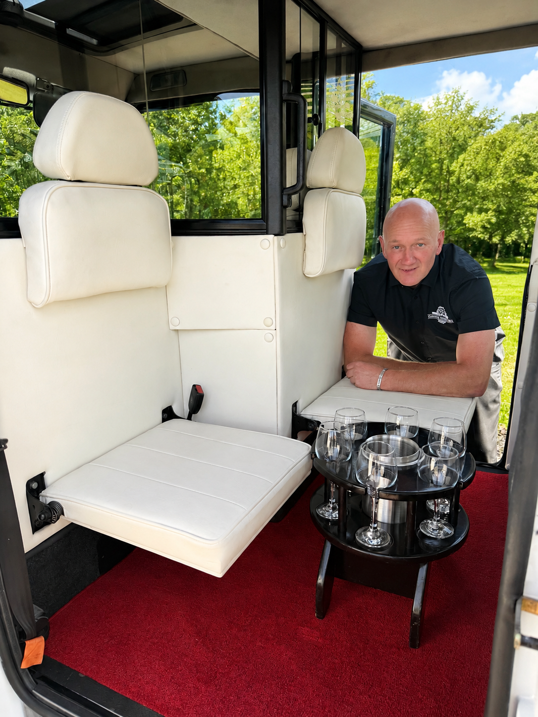Gordon showing the cream leather drop-down seats and champagne table inside the Asquith