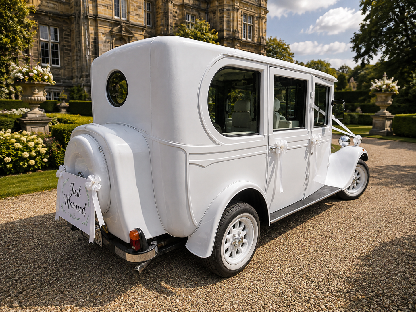 White vintage Asquith with a Just Married sign outside a manor house