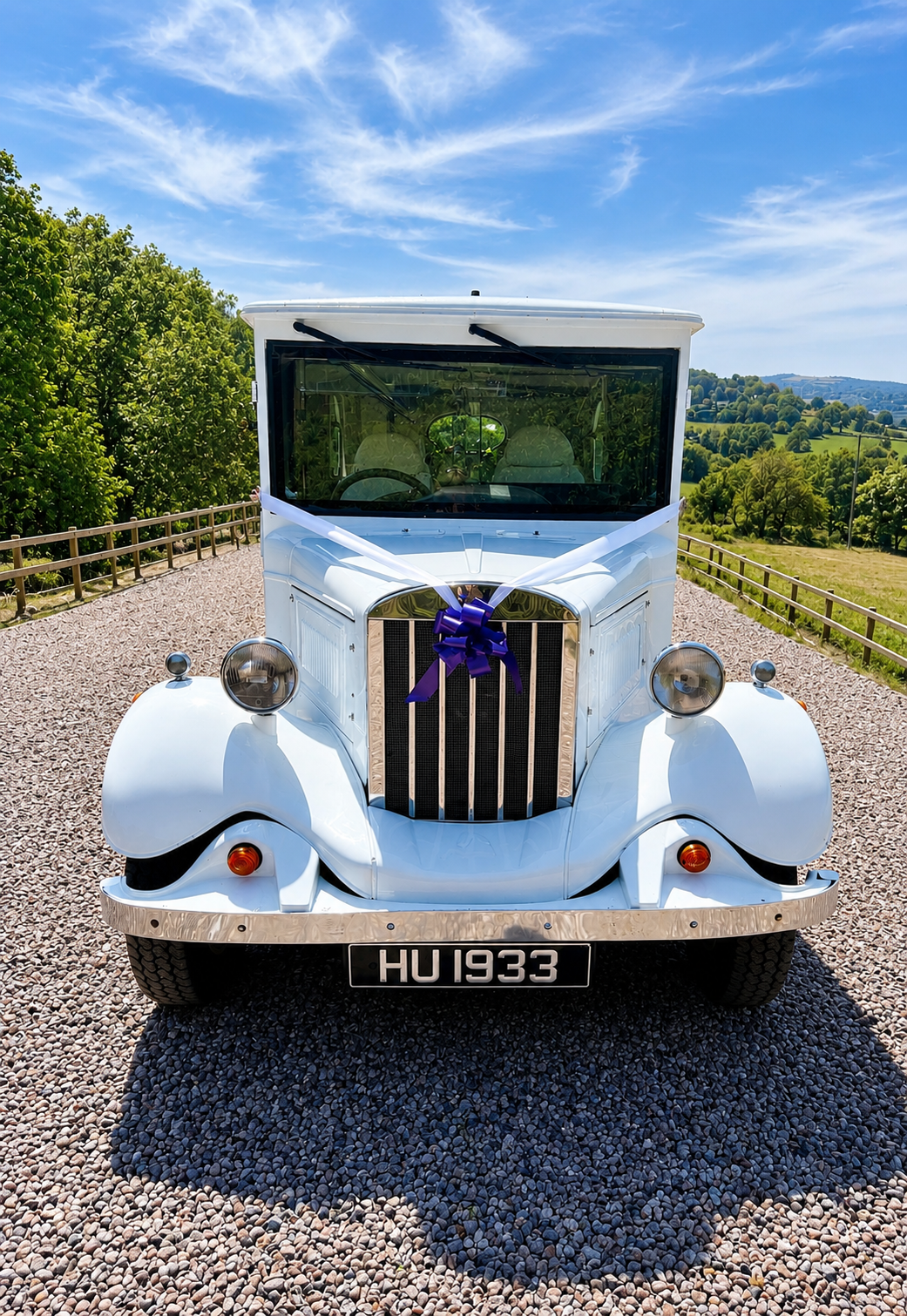Front view of the Frozen White Asquith with purple bow and white ribbons overlooking the countryside